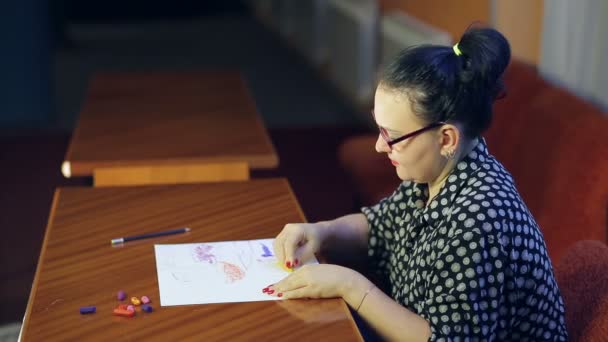 A Jewish artist with glasses paints a pastel landscape on white paper. — Stock Video