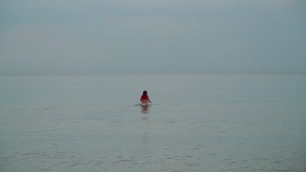 Молода жінка плаває в морі в плавальному колі — стокове відео