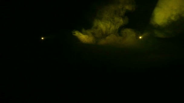 Licht erzeugt gelbe Profilstrahler in der Dunkelheit in einer Rauchdecke. — Stockvideo