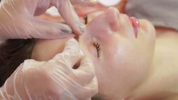 Kosmetyczka myje hennę od klienta s brwi i stosuje specjalny krem — Wideo stockowe