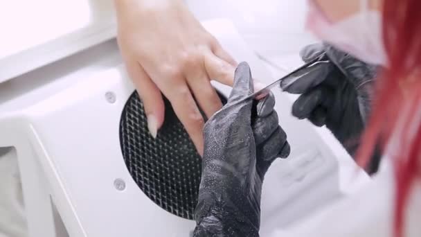 美容室の手袋をはめたマニキュアの女性は、ジェルコーティングを適用する前に爪のファイルでクライアントを爪. — ストック動画