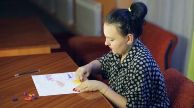 Sanatçı, pastel tekniği kullanarak soyut bir manzara üzerinde çalışıyor. Ortalama plan