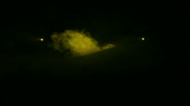 La luz se genera focos de perfil amarillo en la oscuridad en una manta de humo . — Vídeos de Stock