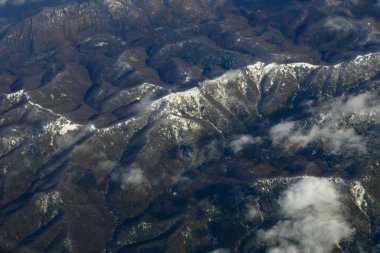 Bulutlarda uçarken uçaktan tepelere kadar manzarası var. Yatay fotoğraf