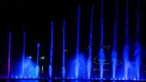 Un espectáculo nocturno de fuentes multicolores brillantes reflejados en el agua — Vídeo de stock