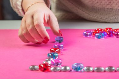 Sevgililer Günü kutlamaları için kadın kalp şeklinde çakıl taşı çerçevesi serer..