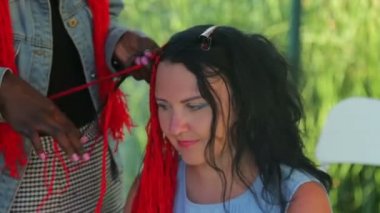 Genç bir Yahudi kadın örgüler örüyor kırmızı ipliklerle Koyu tenli bir kız
