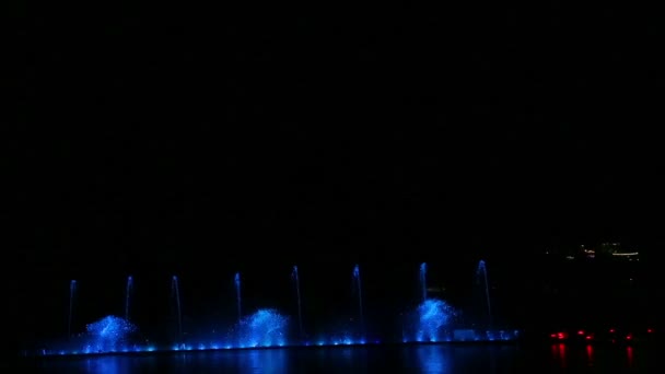 A show of fountains multicolored on the water reflected in the water — Stockvideo