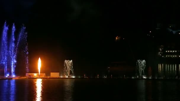 Барвисте яскраве шоу фонтанів на тлі нічного неба, відображеного у воді — стокове відео