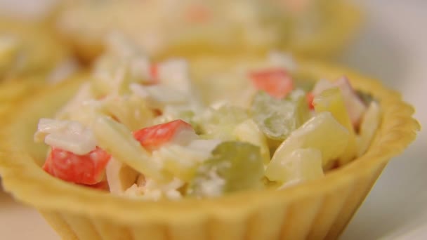 Una mano femenina pone una cucharada de masa de ensalada en tartaletas en un plato blanco — Vídeos de Stock