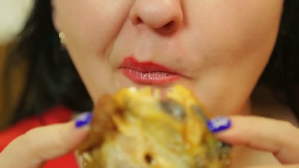 Eine Frau isst gebratenes Huhn und kaut sich den Mund grob — Stockvideo