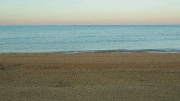 Sandy seashore and blue sea at dawn. — ストック動画