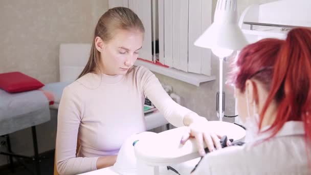 Női manikűrös egy szépségszalonban alkalmazza a matt bevonat géllakk — Stock videók