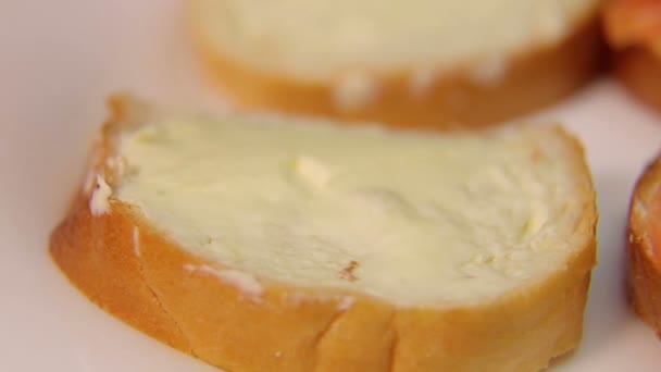 Vrouwelijke hand legt plakjes rode vis op sandwiches met boter — Stockvideo