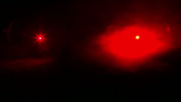 Die roten Strahlen der Profilleuchten in der Dunkelheit in einer Rauchdecke — Stockvideo