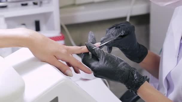 Vrouw manicure met handschoenen in een schoonheidssalon nagels een klant met een nagel bestand voor het aanbrengen van gel coating — Stockvideo