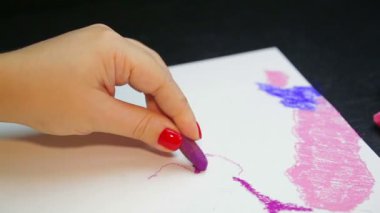Dişi el, akşam gökyüzünü mor pastelle beyaz kağıda çizer. Zaman Kapakları