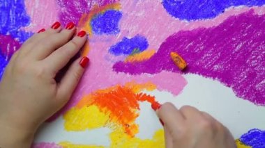 Kadın eli, gün batımında pastel renkli bulutlarla beyaz kağıda resim çizer. Zaman Kapakları
