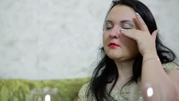 Een brunette vrouw huilt en veegt haar rood ogen — Stockvideo