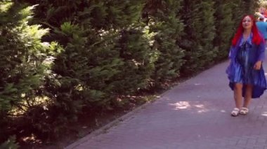 Genç bir kadın parkta yürüyor.