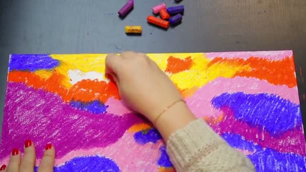 A woman finishes work on a pastel sky landscape at sunset in yellow chalk. — Stock Video