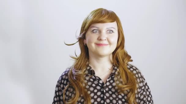 A young woman on a white background shows an emotion of surprise — Stock Video