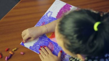 Sanatçı, pastel tekniğini kullanarak günbatımı manzarası üzerinde çalışır.