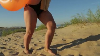 Kadın ayakları sahilde kum üzerinde yalınayak gider