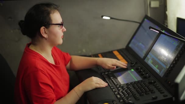 Um programador iluminador fêmea está programando uma luz de palco para um show — Vídeo de Stock