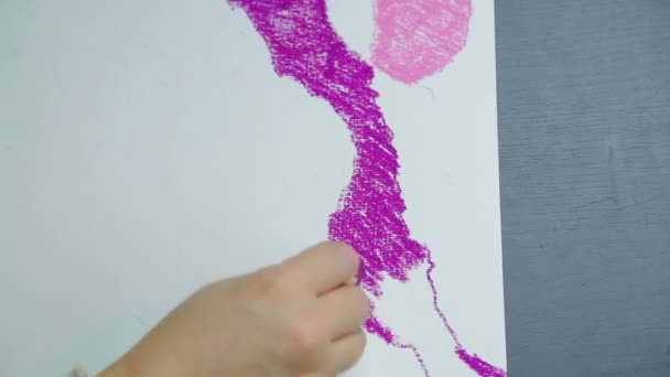 Female hand draws on white paper with purple pastel sky at sunset. — Stock Video