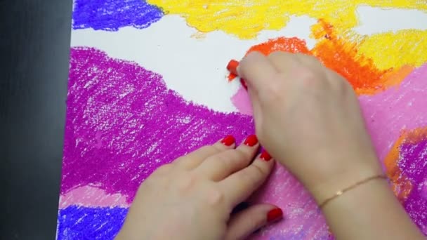 Vrouwelijke hand trekt op wit papier met oranje pastelwolken bij zonsondergang — Stockvideo