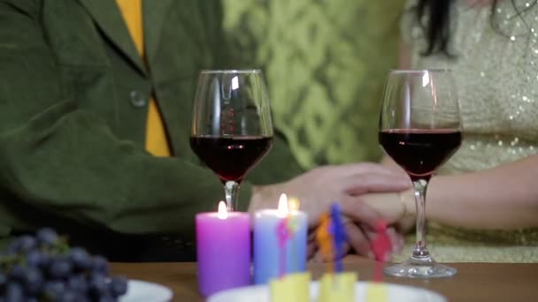 Amar feliz pareja hombre y mujer beber vino tinto mientras se sienta en un sofá en una mesa — Vídeos de Stock