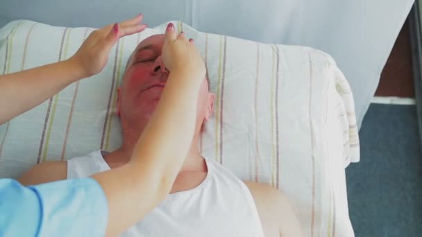 Woman beautician gives man a firming facial massage in a spa salon — Stock Video