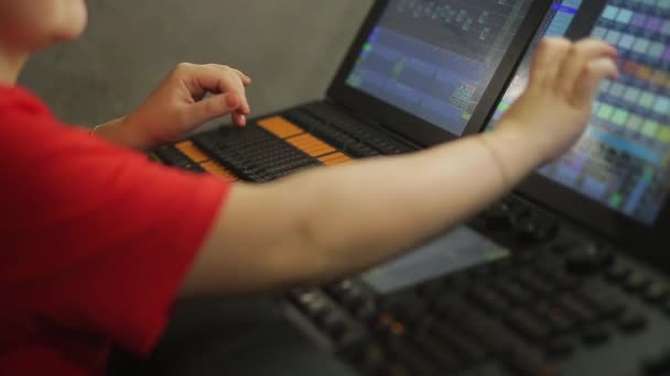 O operador feminino, o iluminador no controle remoto, programa a luz do palco para o show — Vídeo de Stock