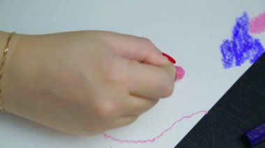 Kadın eli beyaz kağıda pembe tebeşir pastel ile akşam bulutları çizer. Zaman Kapakları