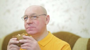 İştahlı bir adam akşam yemeğinde hamburger yer.