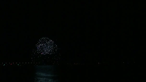 Элегантный праздничный фейерверк в ночном небе над рекой отражается в воде — стоковое видео