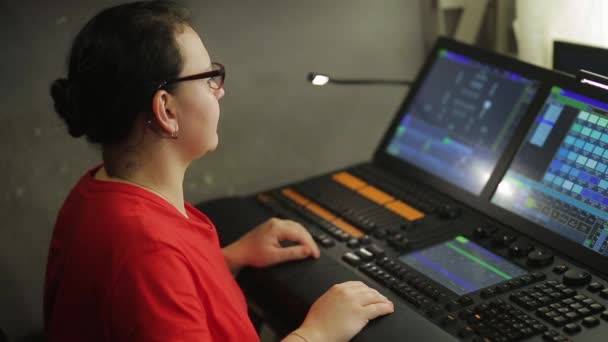 Μια γυναίκα σχεδιαστής φωτισμού στο τηλεχειριστήριο προγράμματα το φως στάδιο για την παράσταση — Αρχείο Βίντεο