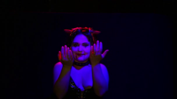 Актриса в образе демона на Хэллоуин со злой улыбкой на лице танцует — стоковое видео