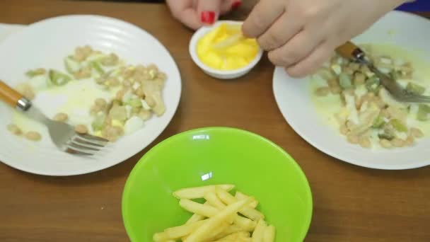 Casamento casal na mesa comendo salada e batatas fritas com molho. Faixas horárias — Vídeo de Stock