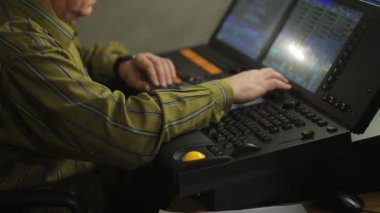 Konsoldaki bir erkek ışıklandırma tasarımcısı şov için sahne ışığını programlıyor.
