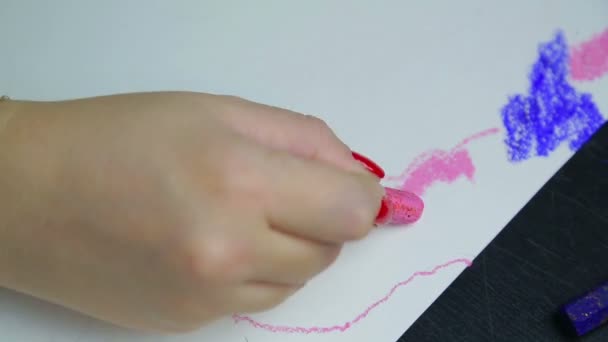 Mão feminina desenha nuvens noturnas em papel branco com giz pastel rosa . — Vídeo de Stock