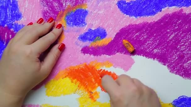 Female hand draws on white paper with orange pastel clouds at sunset — Stock Video