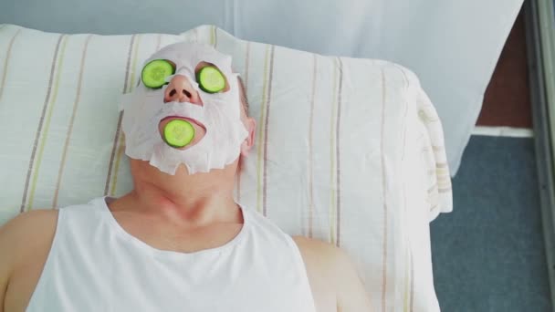 Kvinna kosmetolog gör mannen grönsak ansiktsbehandling i spa salong. — Stockvideo