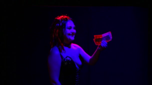 Woman devil with an ominous smile on her face seduces money to sell her soul laughing — Stock Video