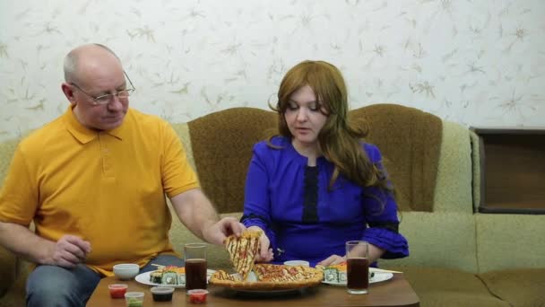 テーブルの上の男と女はピザを食べる — ストック動画
