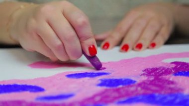 Female hand draws on white paper a pastel sky at sunset. Time Laps