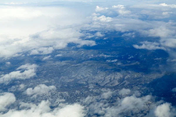 Bulutların üzerinde uçarken tepelerin zirvesinden bir manzara.