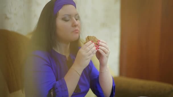 Χαμογελαστή γυναίκα που τρώει ένα μπιφτέκι στην κουρτίνα. — Αρχείο Βίντεο