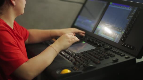 Un illuminateur de programmeur femelle à la télécommande programme la lumière de scène pour le spectacle — Video